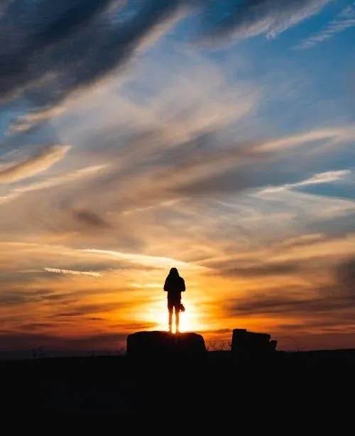 A person standing in the middle of an open field.